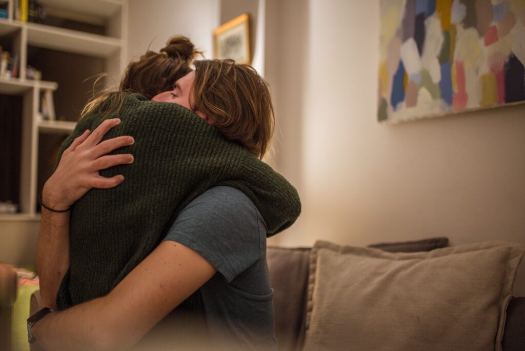 Couple hugging on the couch at home