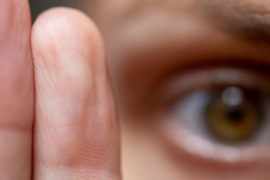 focused image of person's eye with finger in front of it