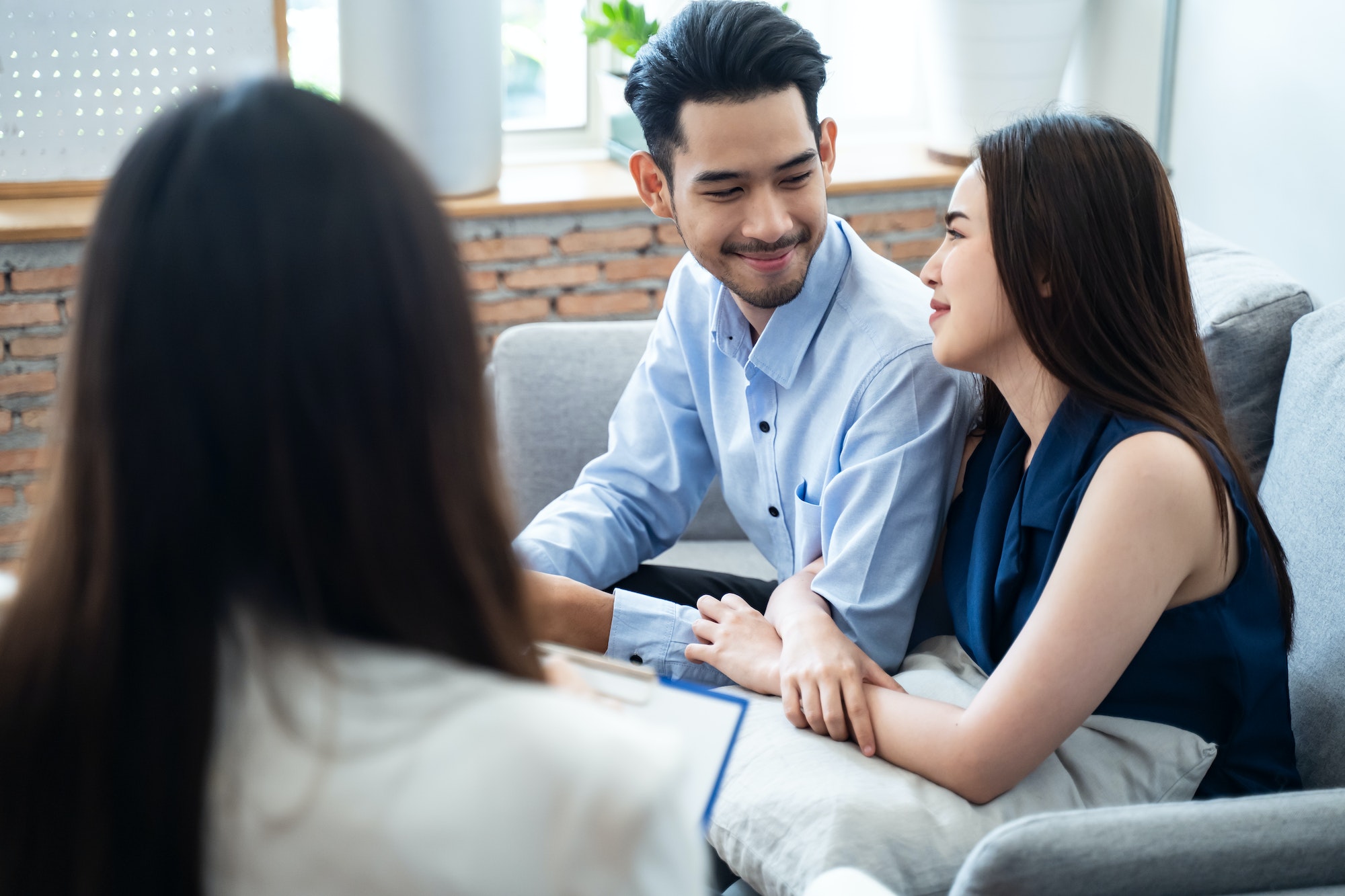 Asian couple explaining and consulting problem to professional psychologist female.