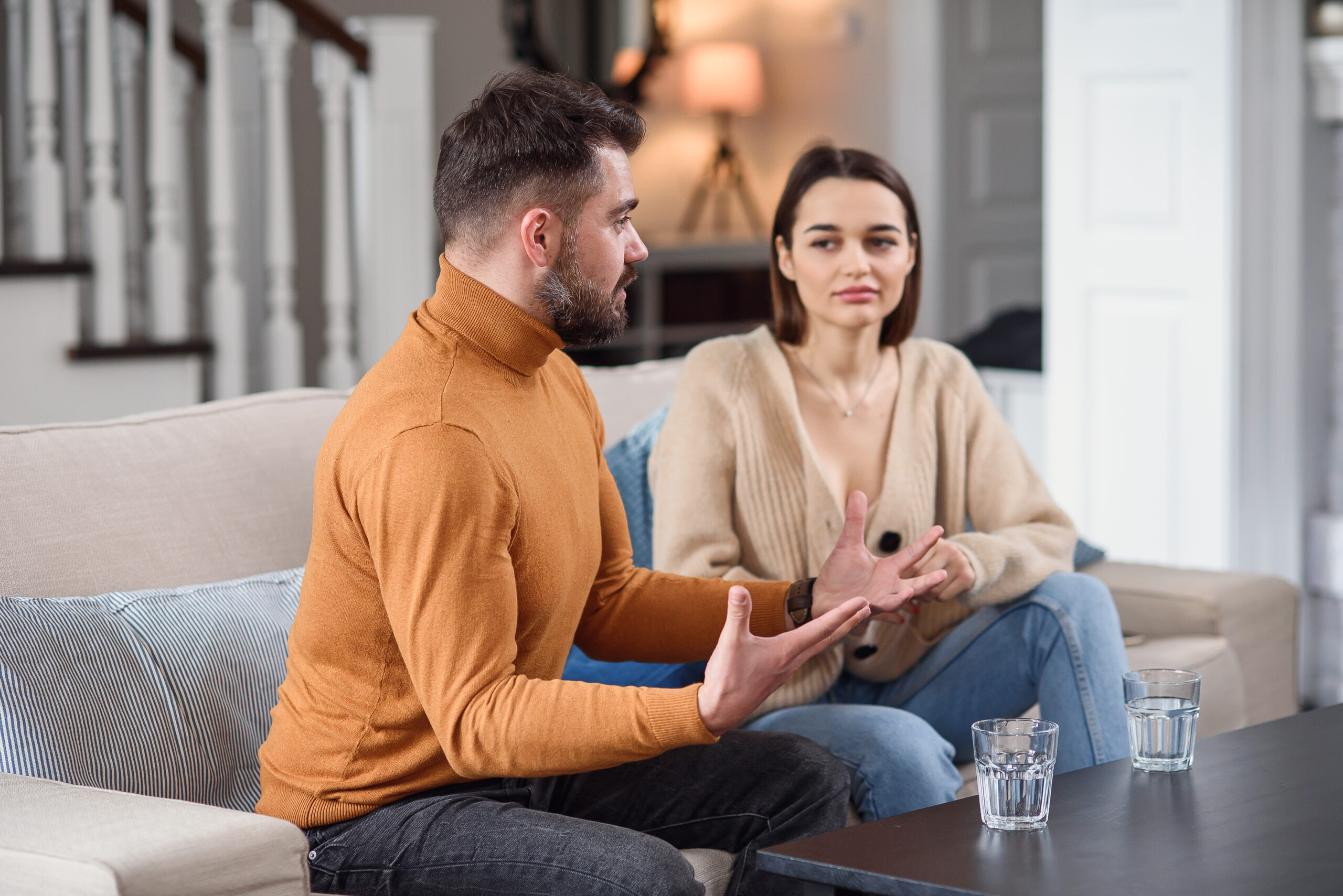 couple arguing while sitting on couch