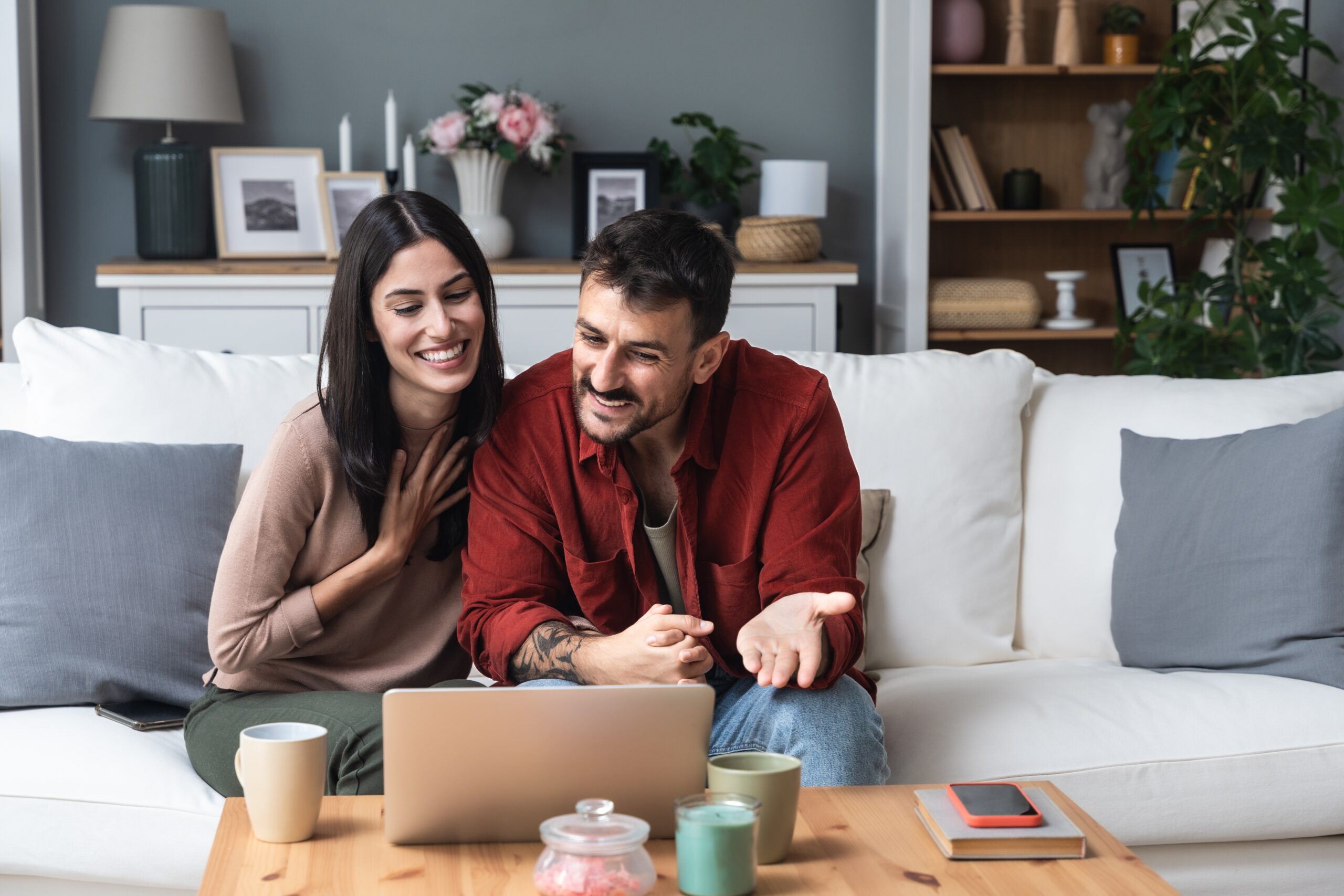 happy couple attending telehealth therapy on computer