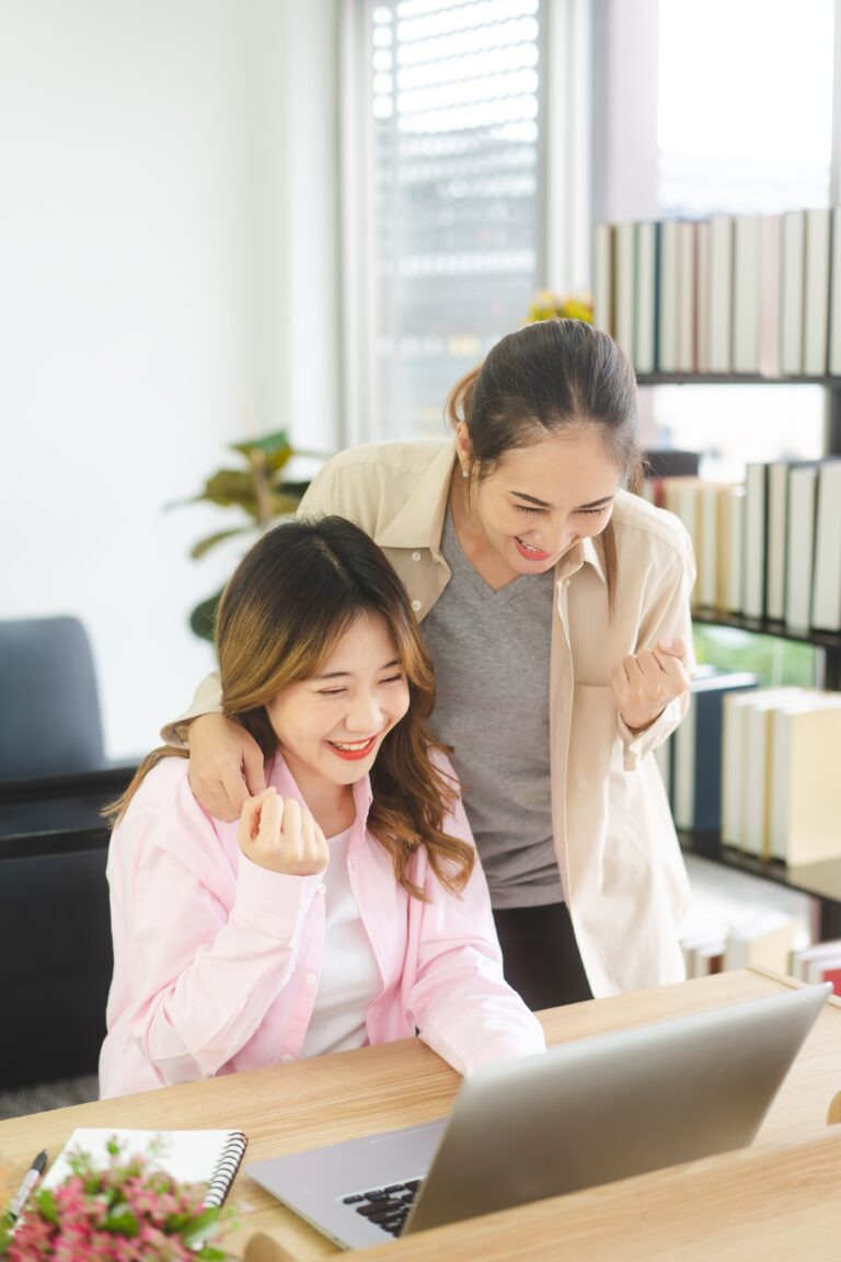 women smiling looking at a computer